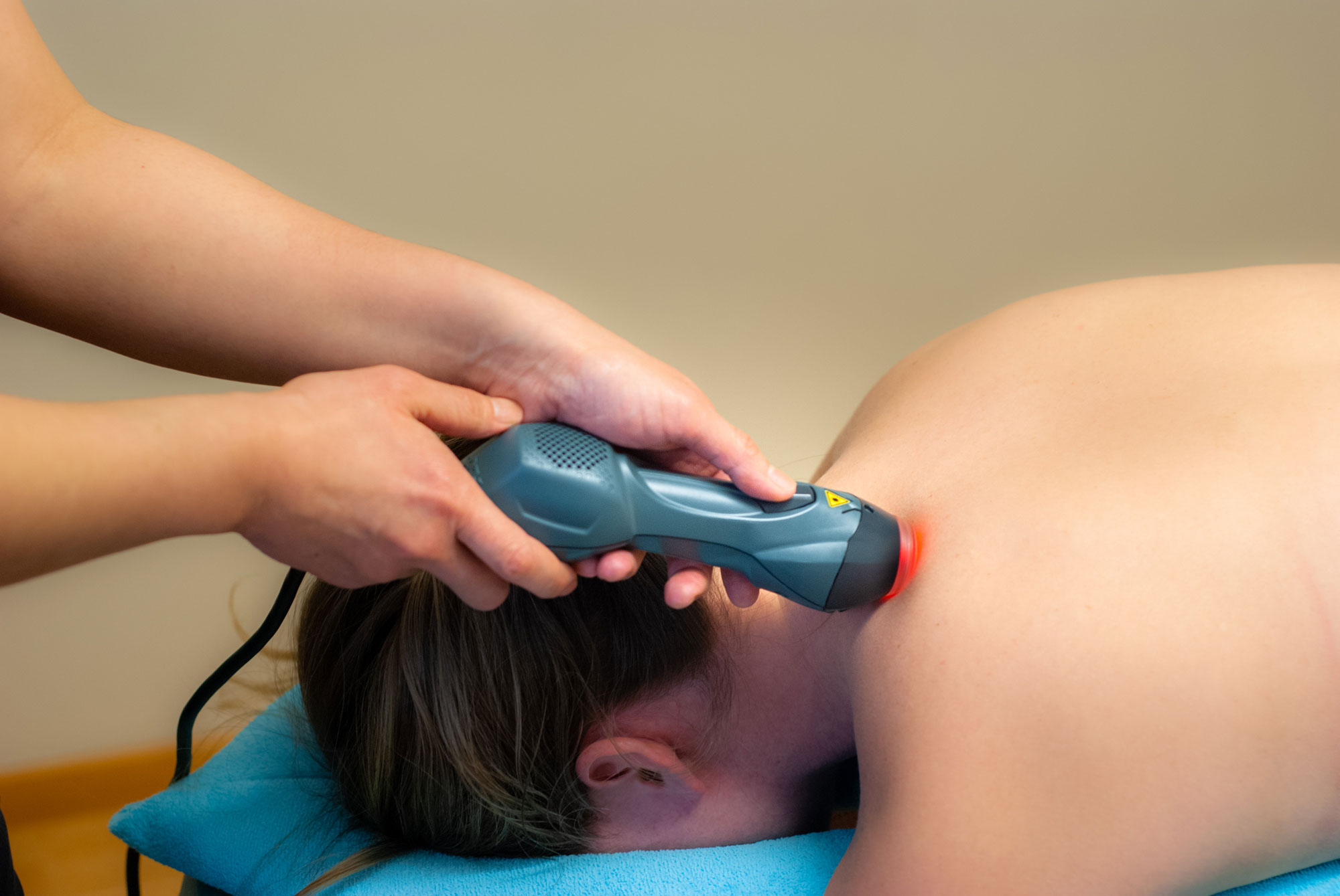 En patient som blir behandlad med laserterapi på sin axel med en apparat